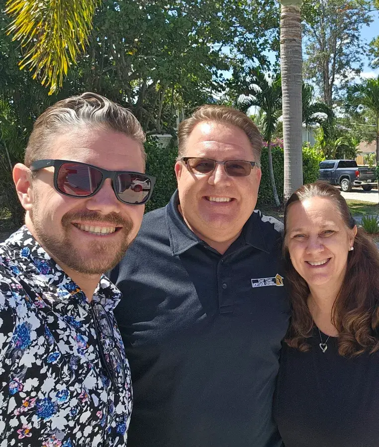 Michael with two people outdoors at an event