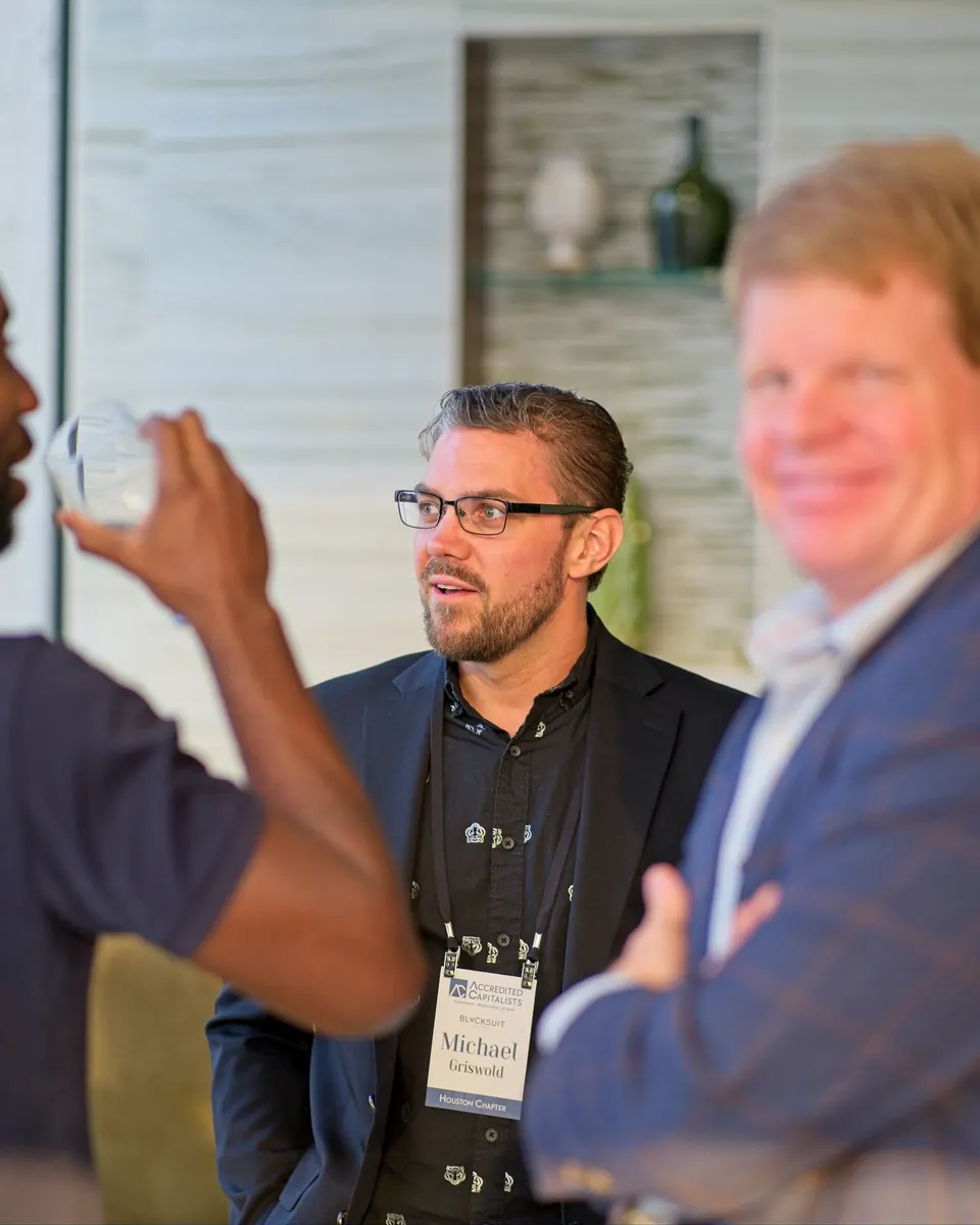 Michael Griswold wearing his Accredited Capitalists Houston badge at one of his events